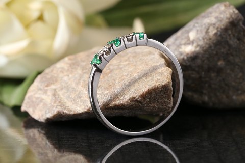 Alliance ring in 14 carat white gold, with inlaid emeralds and brilliants. 
Stamped BOOK, size 58