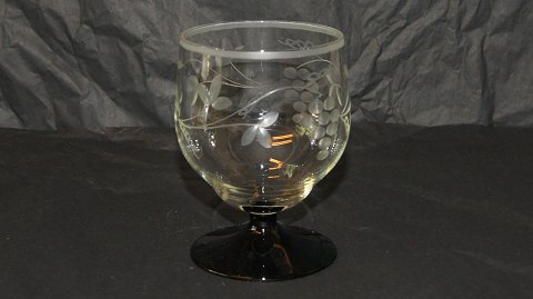 Red wine glass with black base and grape vine