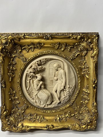 Picture: A seated woman and a standing man. Carved out of marble.H 29.2 X W 29.2 cm.