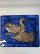 Relief of ceramics with a motif of ducks on a blue background.560/2903
